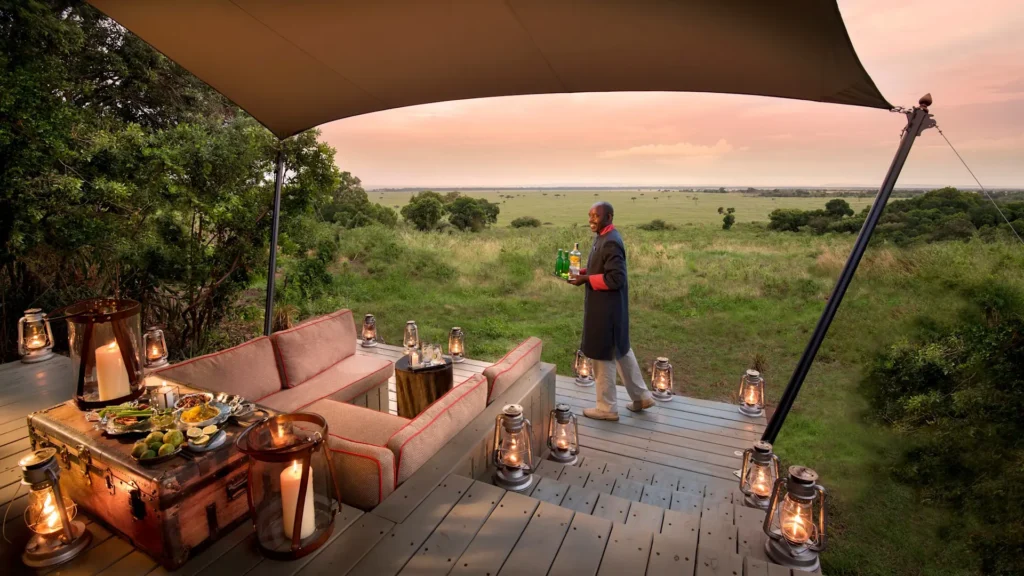Garçon com bebidas com a savana em plano de fundo
