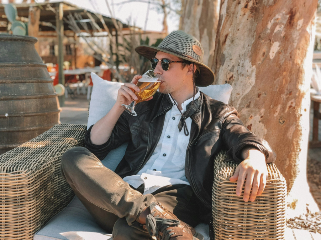 pessoa de óculos escuros a beber cerveja 
